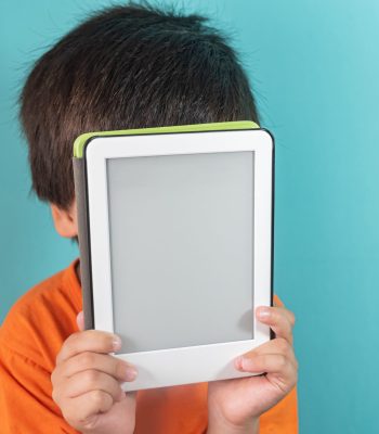 Boy in orange t-shirt holding ebook reader